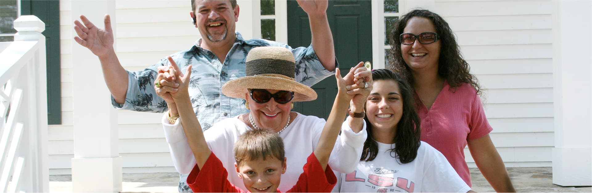 Smiling people in front of white building